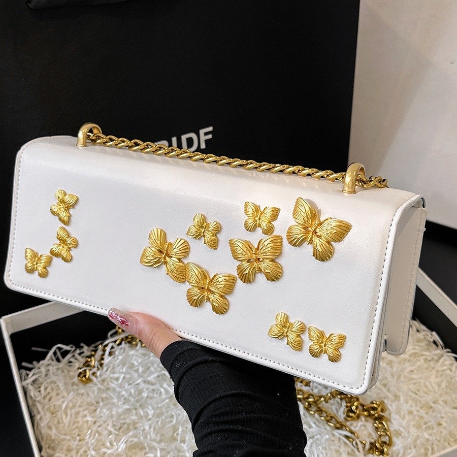 2026/04/1000235531.jpg PU leather shoulder bag features decorative gold-toned butterfly embellishments and a matching gold chain strap - Image 1